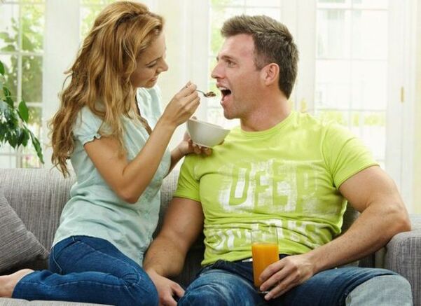 ქალი აჭმევს მამაკაცს პროდუქტებით პოტენციის ასამაღლებლად